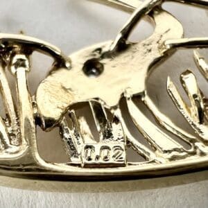 Gold pendant with intricate animal design.