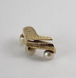 Gold piano brooch with pearl accents.