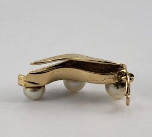 Gold oyster clasp with pearl accents.