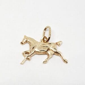 Gold horse charm on white background.