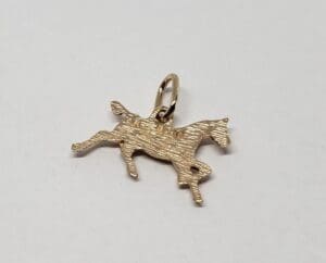 Gold horse charm on white background.