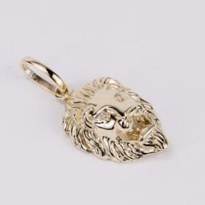 Gold lion head pendant with gemstones.
