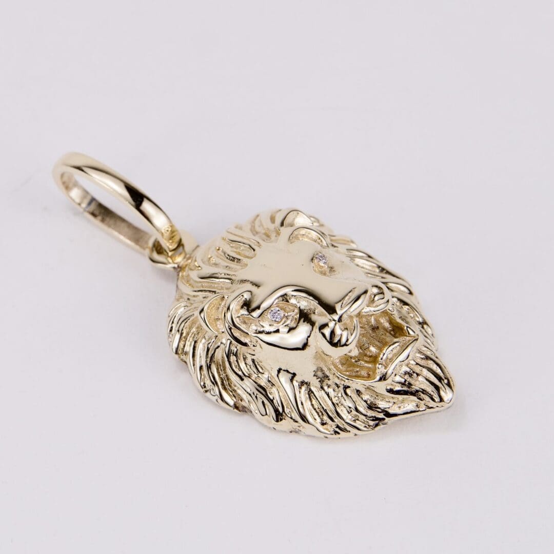 Gold lion head pendant with gemstones.