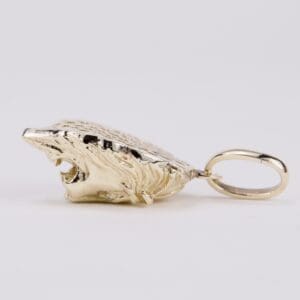 Gold wolf head pendant on white background.