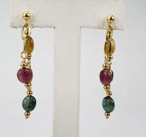 Gold and gemstone dangle earrings on display.