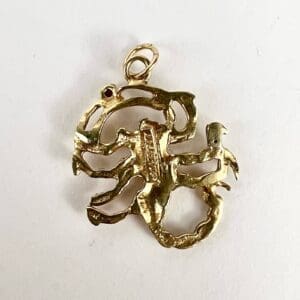 Gold Scorpio zodiac pendant on white background.