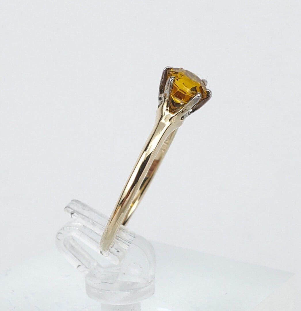 Gold ring with a yellow gemstone.