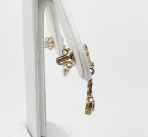 Gold jewelry displayed on white stand.