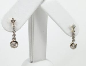Silver drop earrings with diamond accents displayed.