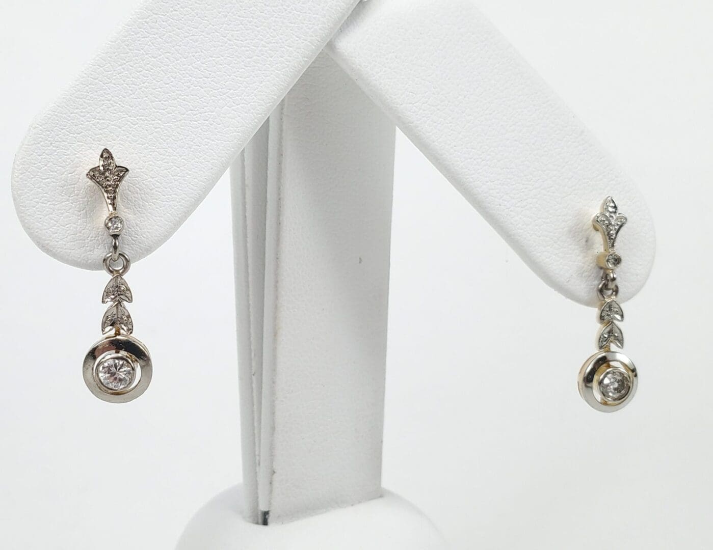 Silver drop earrings with diamond accents displayed.