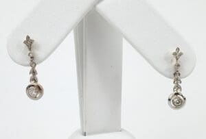 Silver earrings with diamond accents on display.