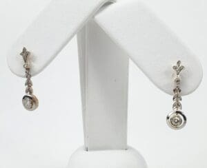 Elegant silver and gold dangling earrings displayed.