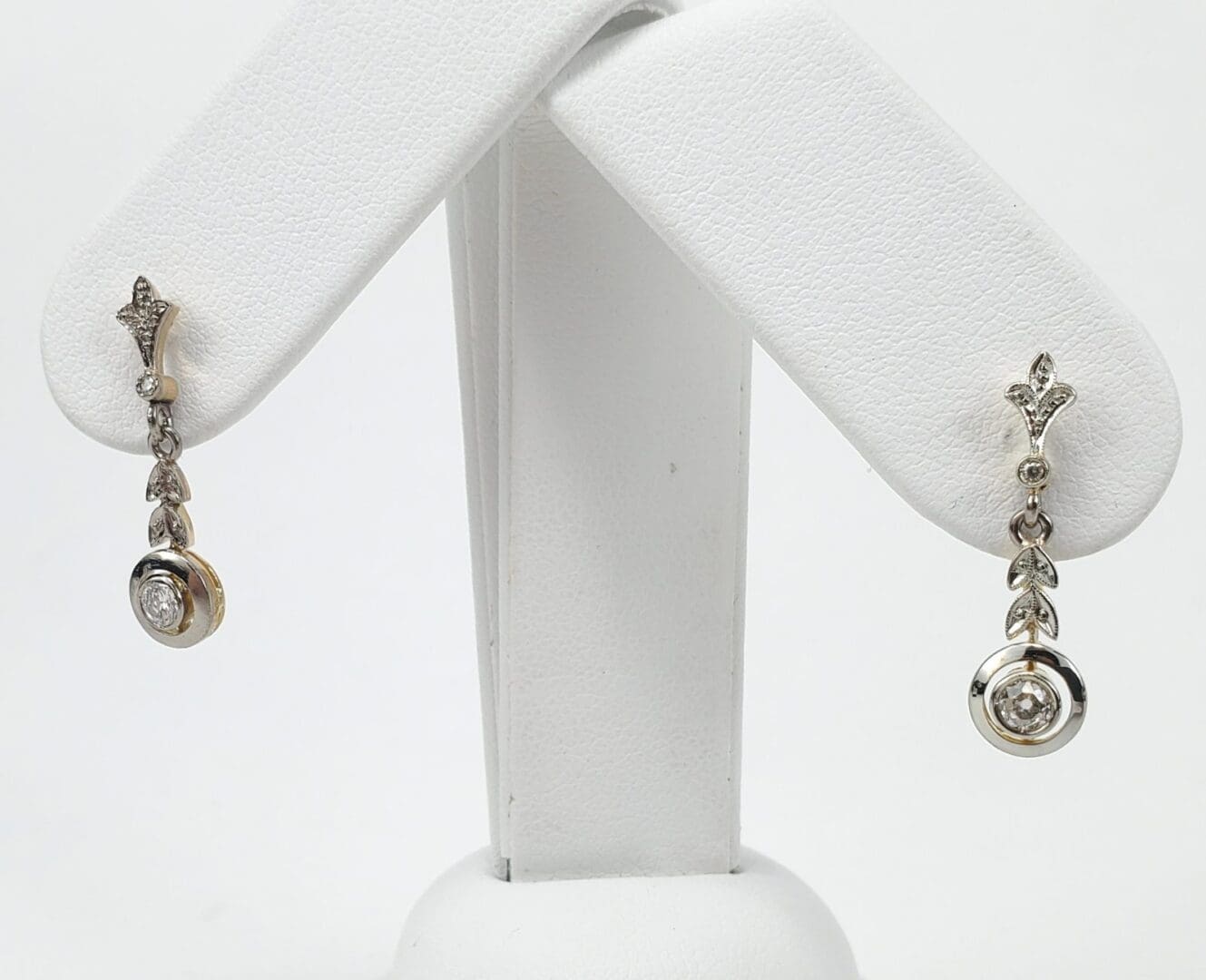 Elegant silver and gold dangling earrings displayed.