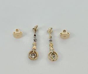 Gold earrings with arrow design and stones.
