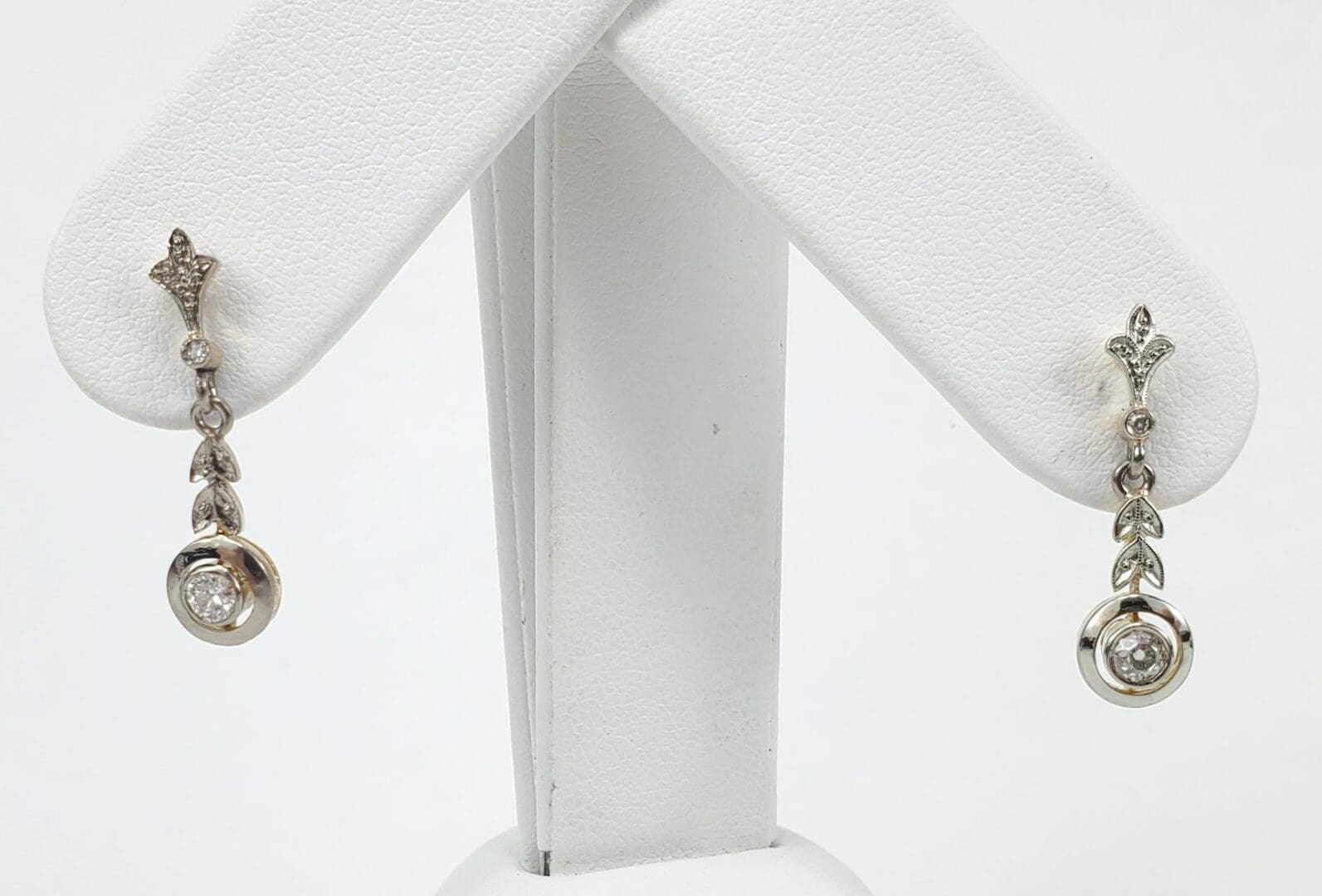 Silver earrings with diamond accents on display.