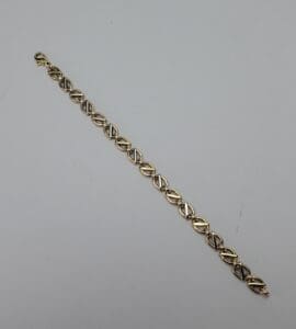 Gold link bracelet on white background.