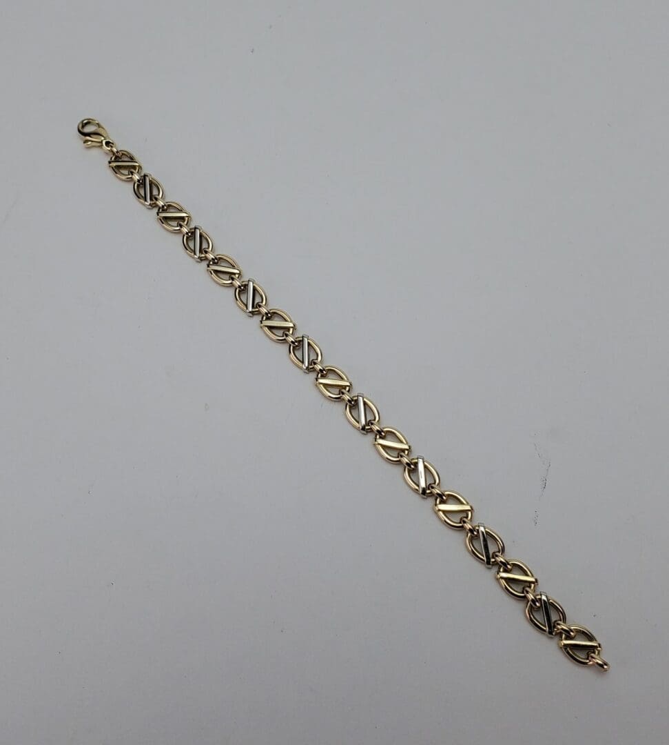 Gold link bracelet on white background.