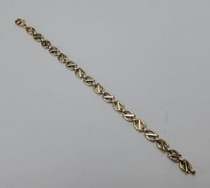 Gold chain bracelet on white background.