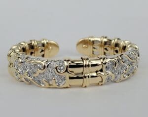 Gold bracelet with intricate diamond detailing.