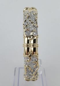 Gold bracelet with intricate silver detailing.