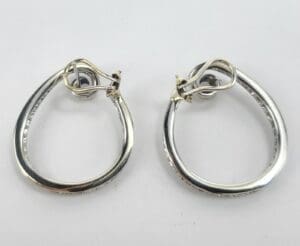 Silver teardrop-shaped hoop earrings on display.