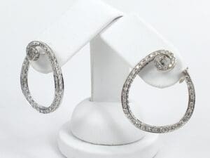 Silver hoop earrings with spiral design.