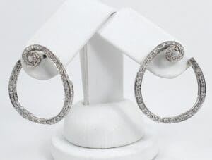 Silver hoop earrings with sparkling stones displayed.