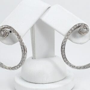 Silver hoop earrings with sparkling stones displayed.