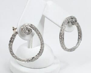 Silver hoop earrings with spiral design.