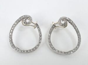 Silver spiral earrings with embedded diamonds.