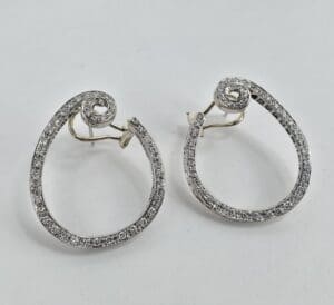 Silver spiral earrings with diamond accents.
