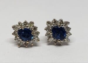 Silver earrings with blue gemstone center.
