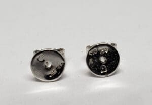 Two round silver-colored earring backs.