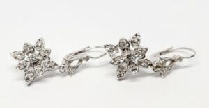 Silver flower-shaped earrings with gemstones.