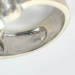 Silver ring with engraved markings inside band.