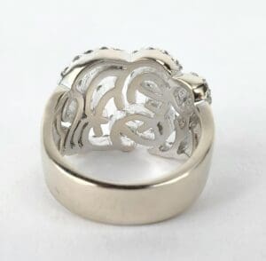 Silver ring with intricate, swirling design underside.