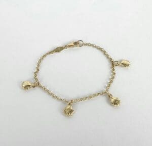 Gold bracelet with shell charms on display.