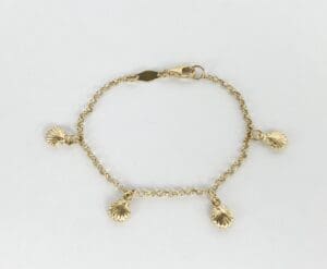 Gold bracelet with shell charms on display.