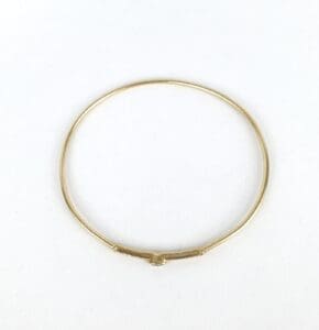 Gold bangle bracelet on white background.