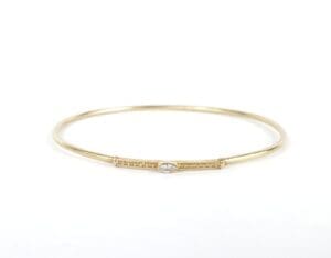 Gold bangle with small diamond detail.