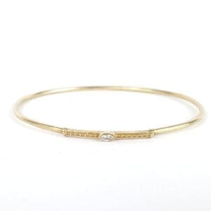 Gold bangle with small diamond detail.