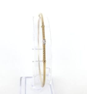 Gold bracelet with central oval gemstone.