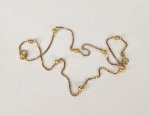 Gold chain necklace with round beads.