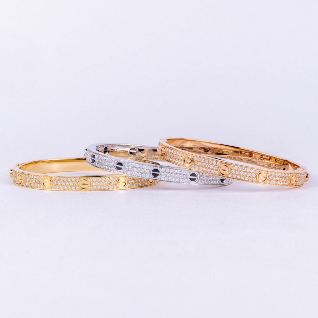 Three elegant gold and silver bracelets.