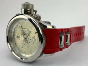 Silver watch with red strap, white face.
