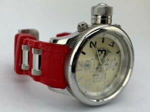 Silver watch with red strap on display.