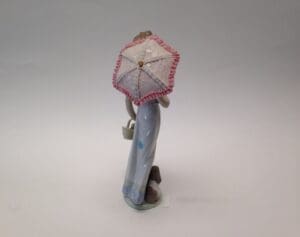 Figurine with umbrella and small dog.