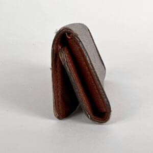 Brown leather wallet standing upright.
