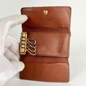 Brown leather key holder with gold hooks.