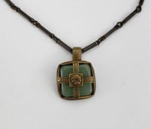 Bronze pendant with green stone center.